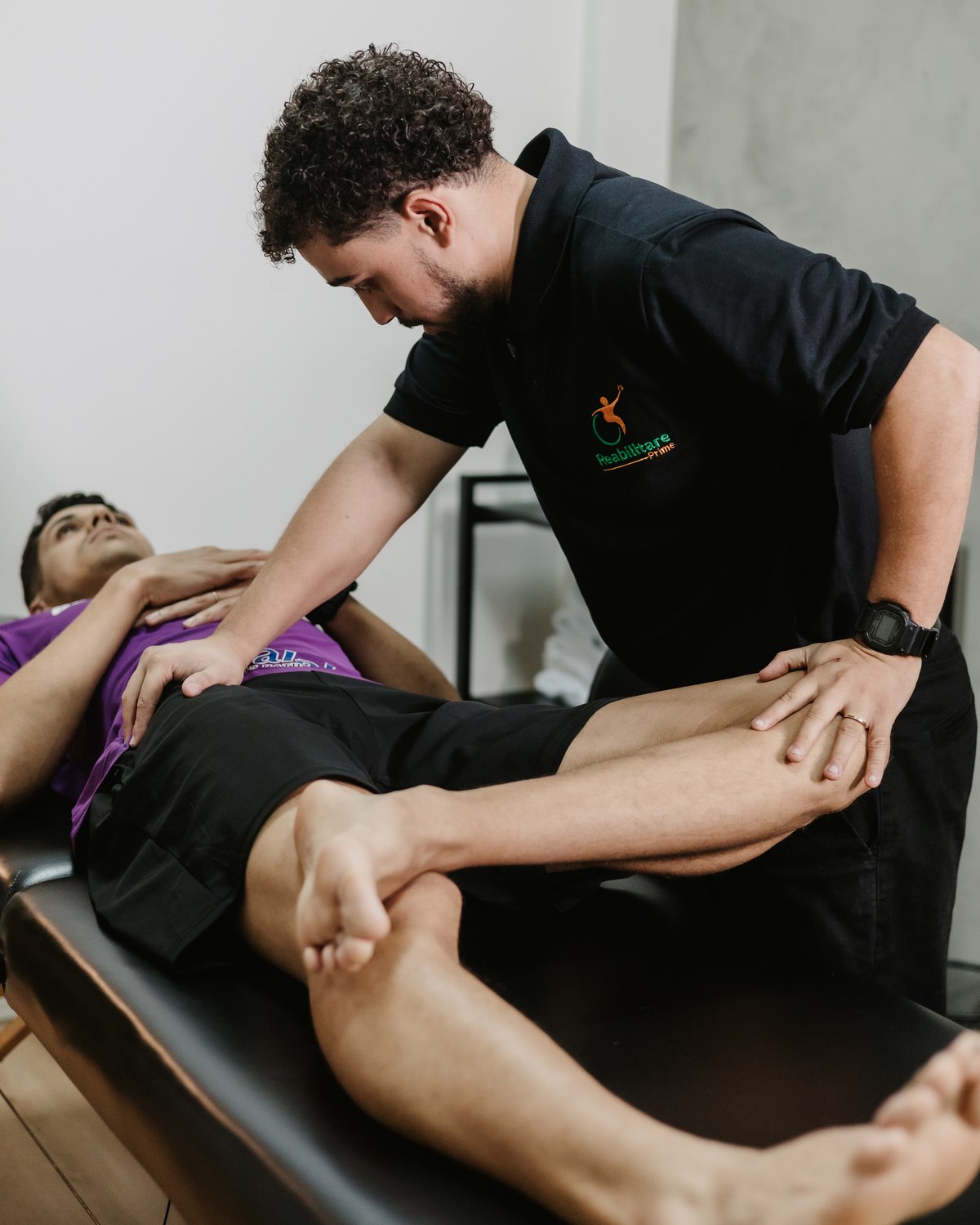Fisioterapeuta mobilizando o joelho de um paciente